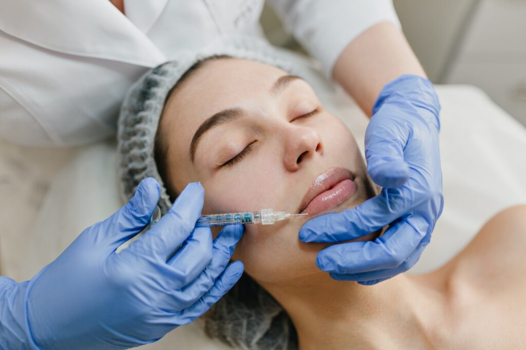 Closeup portrait of beautiful woman during cosmetology therapy in beauty salon. Botox, lips, injecti